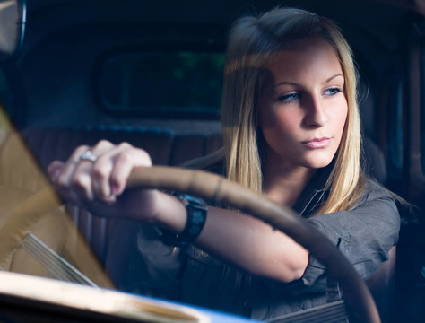 美麗的年輕金發(fā)女孩在黑色老爺車。