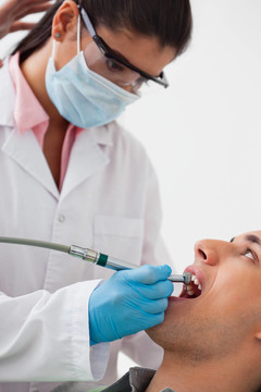 牙医在病人牙齿上钻孔