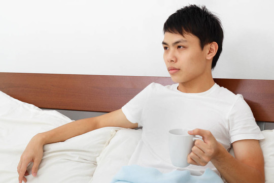 男人在床上喝咖啡