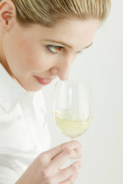 女人品嘗白葡萄酒