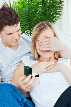 有魅力的男人在客廳里用結(jié)婚戒指給女友做驚喜
