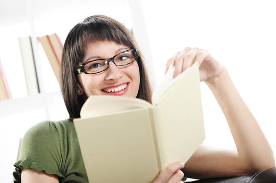 年輕的女人與書的書架在BAC明亮的畫面；