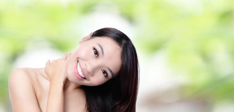 美麗的亞洲女孩微笑著觸摸她的肩膀