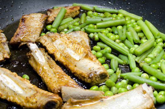 用煎鍋煎豌豆和青豆的排骨