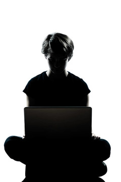 一個(gè)白人年輕的青少年剪影男孩或女孩電腦計(jì)算筆記本電腦全長(zhǎng)在工作室削減孤立的白色背景