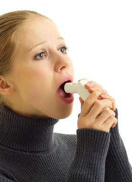 年輕的女人抱著哮喘吸入器