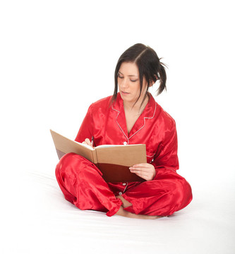 年輕女子穿著紅色睡衣盤腿坐著