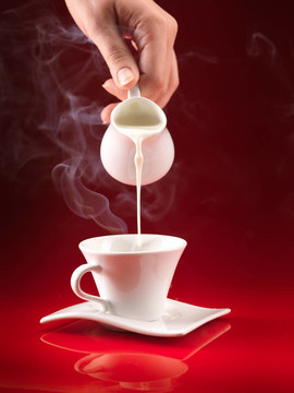 咖啡杯手倒牛奶