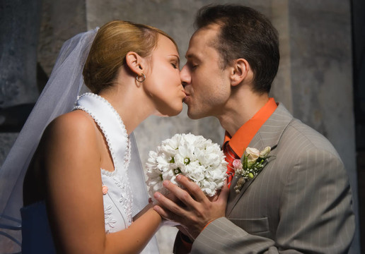 剛結(jié)婚的情侶抱著一束圓圓的白花