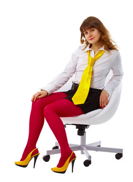 美麗的女人在明亮的衣服在椅子上