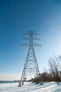 冬季湖旁輸電線路高壓輸電鐵塔。