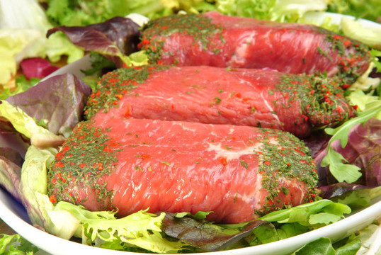 新鮮的有機(jī)牛肉卷盤子上