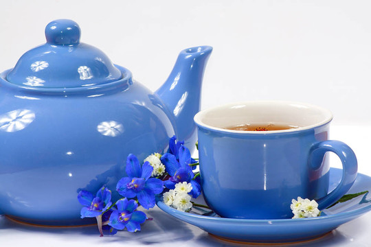 藍(lán)色水壺和一杯有花的茶