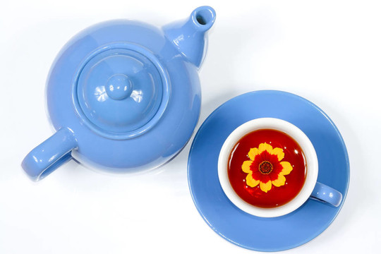 藍(lán)色水壺和一杯有花的茶
