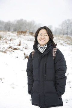 微笑的東亞婦女在白雪覆蓋的里士滿公園
