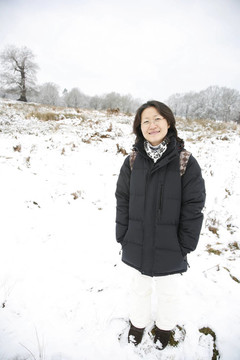 微笑的東亞婦女在白雪覆蓋的里士滿公園