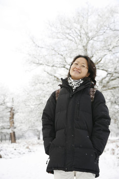 微笑的東亞婦女在白雪覆蓋的里士滿公園