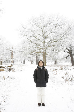 微笑的東亞婦女在白雪覆蓋的里士滿公園