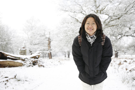 微笑的東亞婦女在白雪覆蓋的里士滿公園