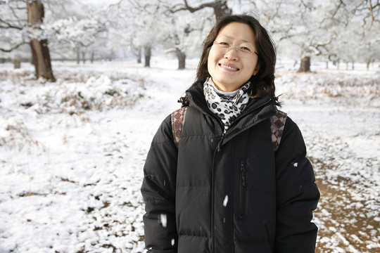 微笑的東亞婦女在白雪覆蓋的里士滿公園
