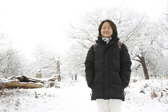 微笑的東亞婦女在白雪覆蓋的里士滿公園