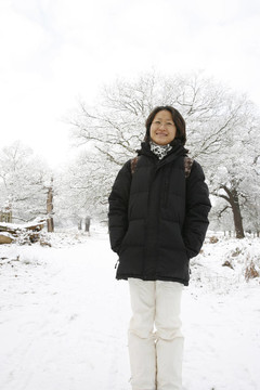 微笑的東亞婦女在白雪覆蓋的里士滿公園