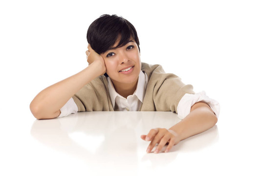 微笑的混血兒年輕女性坐在白桌子上