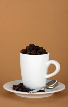用咖啡豆和银匙白咖啡杯