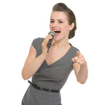 快樂的女人在麥克風(fēng)唱歌，指著你孤立