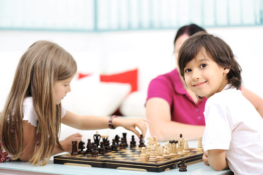 哥哥和妹妹在家下棋和他們的母親