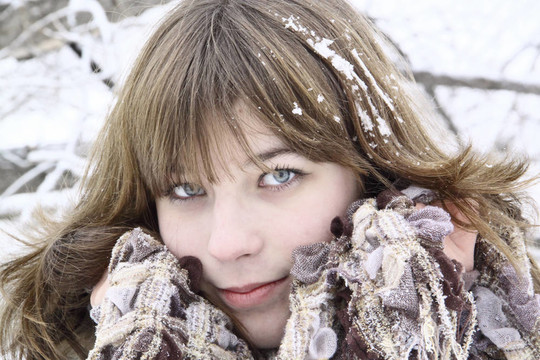 漂亮的女孩帶著圍巾和雪在頭發(fā)上