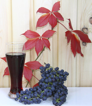一杯葡萄酒和葡萄對紅樹葉和木