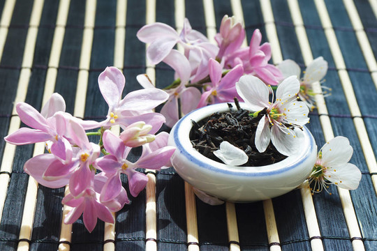 一盆茶葉和丁香花在竹臺(tái)布上仍存著生命