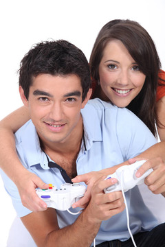年輕夫婦一起玩電子游戲