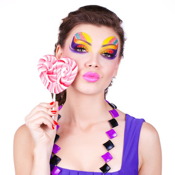 一個(gè)有魅力的美麗的女人拿著棒棒糖的肖像