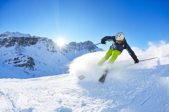 在晴朗的日子里在冬天的雪上滑雪