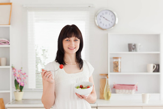 漂亮的黑發(fā)女性吃櫻桃番茄