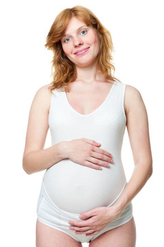 年輕的孕婦把手放在肚子上
