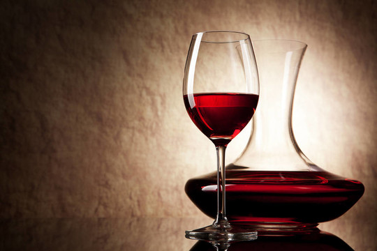 在旧石器时代背景的红葡萄酒和玻璃酒瓶