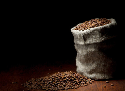 麻袋的咖啡豆在深色木纹背景