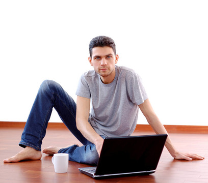 Young Man Sitting與筆記本電腦在家里