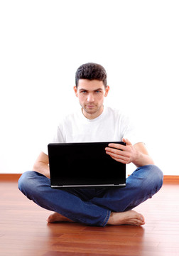 Young Man Sitting與筆記本電腦在家里