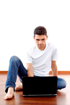 Young Man Sitting與筆記本電腦在家里