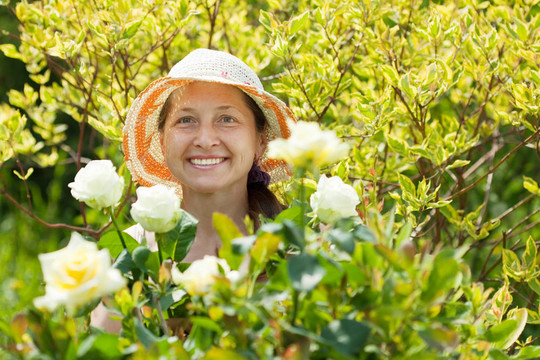 快樂的成熟女人與玫瑰植物
