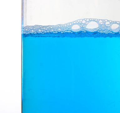 在白色背景的塑料容器中制作泡沫蓝色清洗液