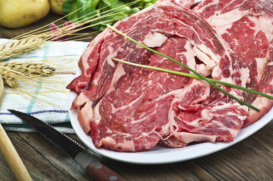 迷迭香上木桌子的烤牛肉