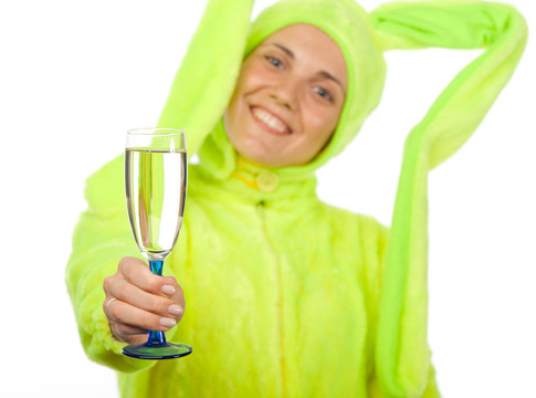 有趣的女孩在兔服裝與酒杯
