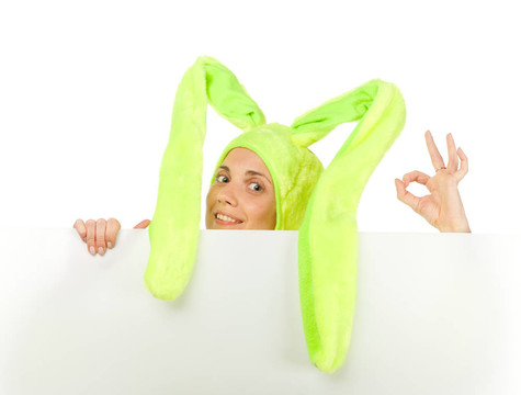 有趣的女孩在兔子服裝與空白板