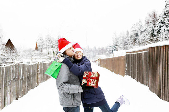 Santa帽子戶外送禮的年輕夫婦吸引人