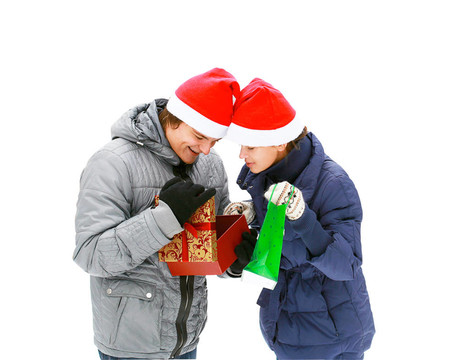 Santa帽子送禮戶外孤立在白色的年輕夫婦吸引人